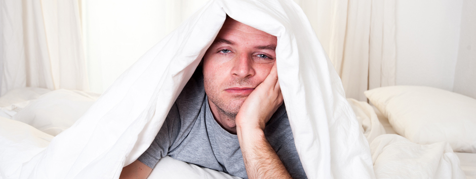 Sorgenvoller Mann mit Decke überm Kopf